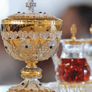 Ornate golden chalice with cross lid used in Catholic Mass
