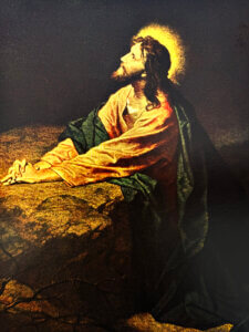 Jesus praying in the Garden of Gethsemane with a halo of light