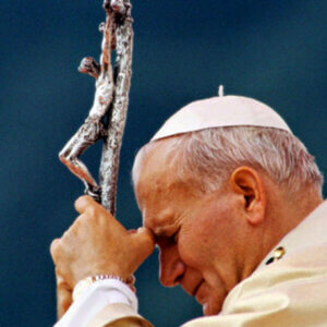 Pope John Paul II praying with a crucifix during reflection