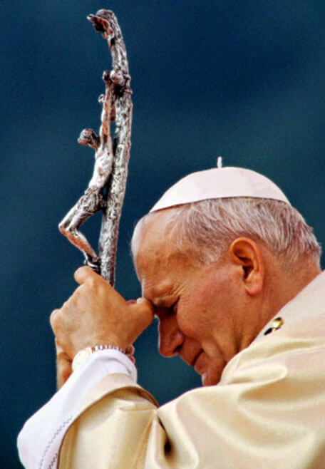 Pope John Paul II praying with a crucifix during reflection