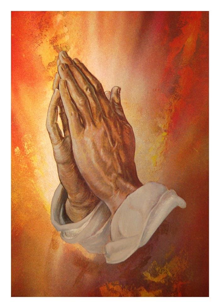 Praying hands on a warm, glowing background.