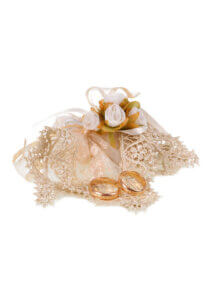 Two gold rings on lace with white roses
