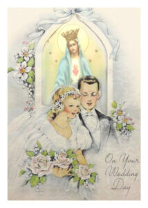 Bride and groom with Virgin Mary in background.