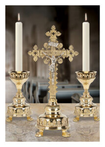 Golden crucifix with two lit candles on altar